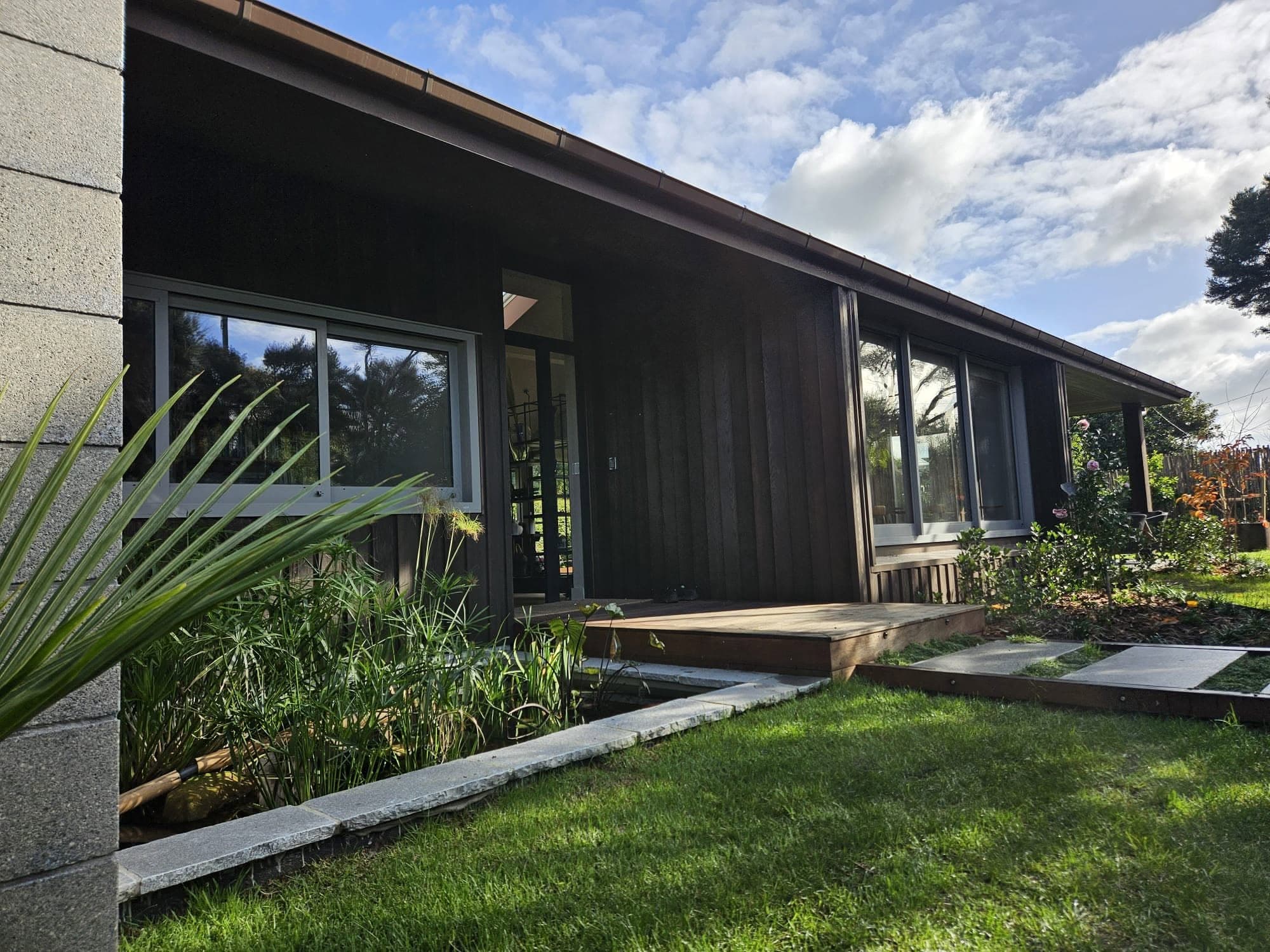 Dark-clad home exterior with timber deck